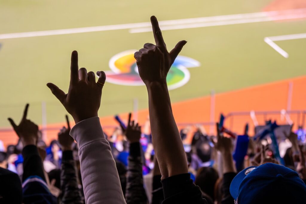 Fans holding phones with crypto wallet apps at a large sports stadium